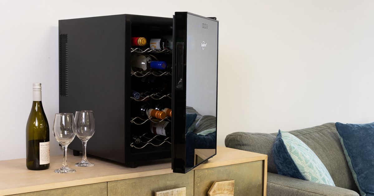 Photo of Koolatron's 20 bottle single zone wine cooler on a gold-colored sideboard beside a gray sofa