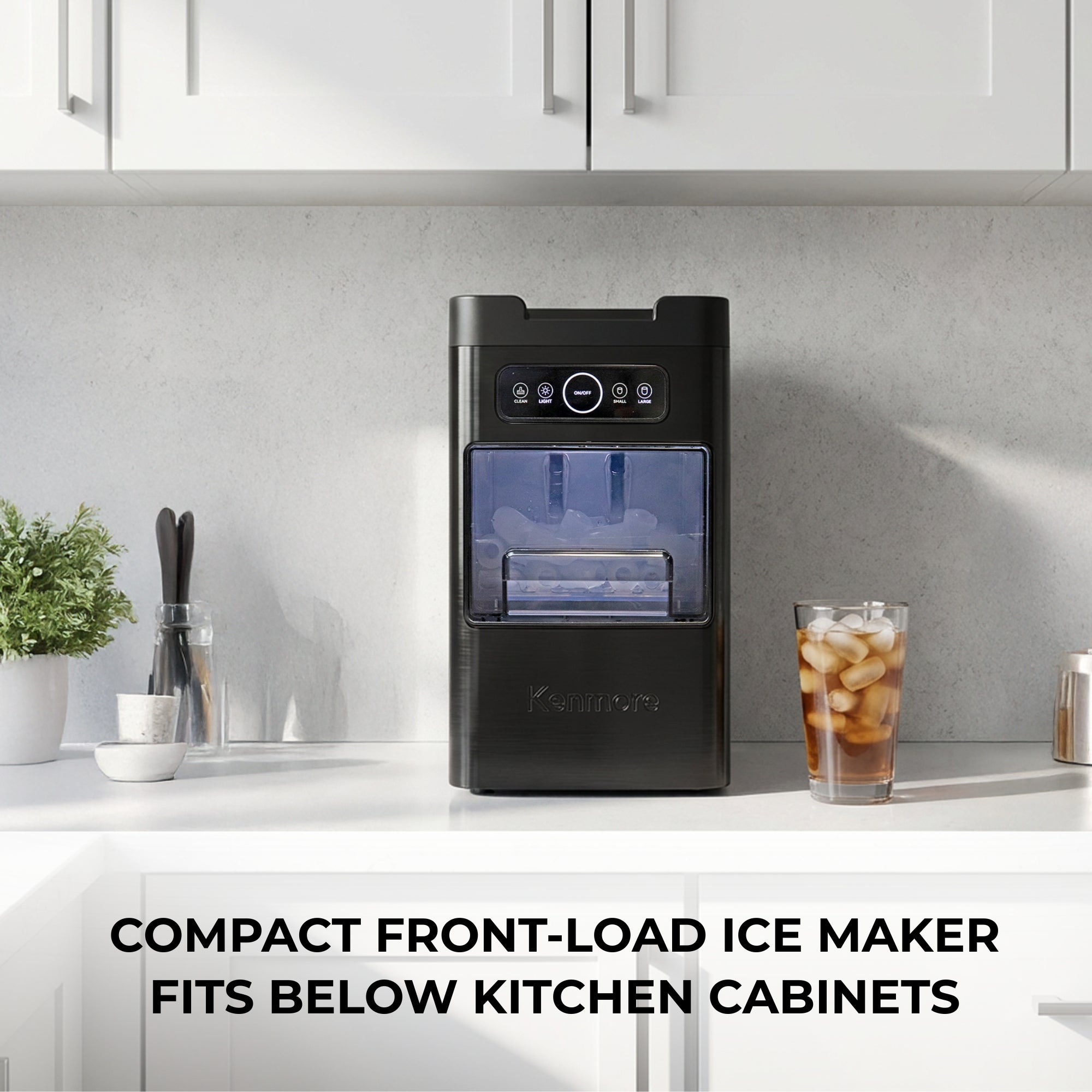 Kenmore front-load bullet ice maker in a bright kitchen with white cabinets above and below it. Text above reads, "Compact front-load ice maker fits below kitchen cabinets."