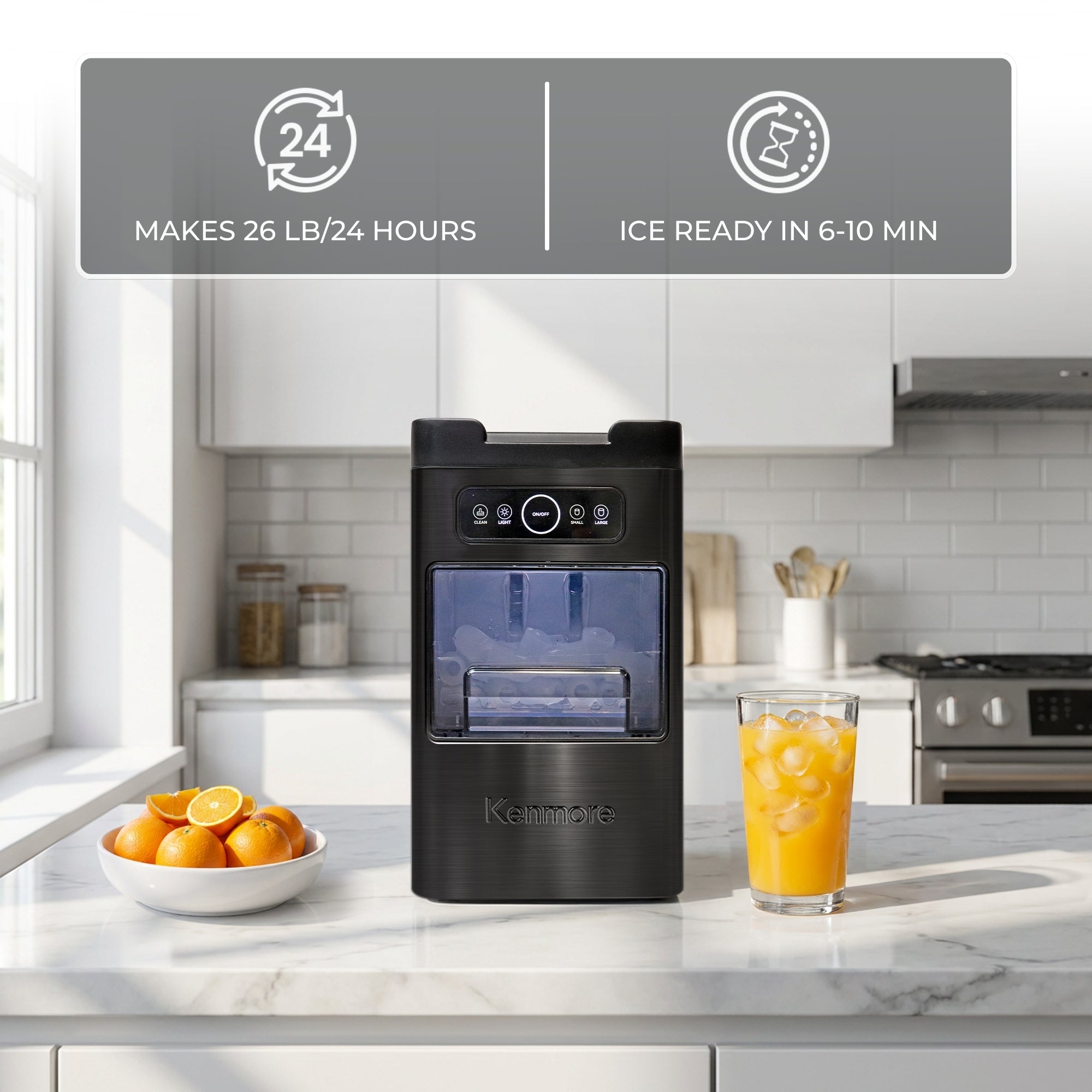 Kenmore automatic front-load ice maker on a white counter with oranges and a glass of orange juice arranged around it. Text and icons above read, "Makes 26 lb/24 hours" and "Ice ready in 6-10 min"
