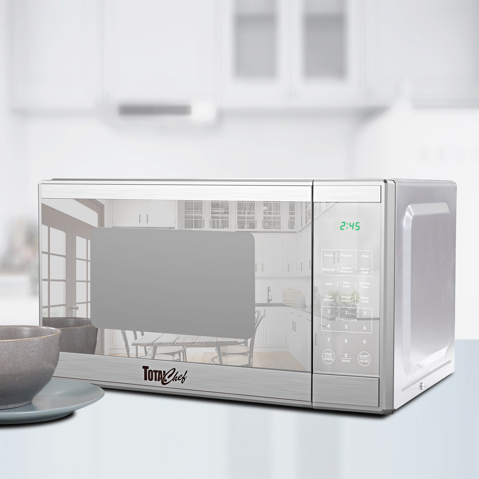 Total Chef stainless steel microwave, closed, on a white kitchen counter