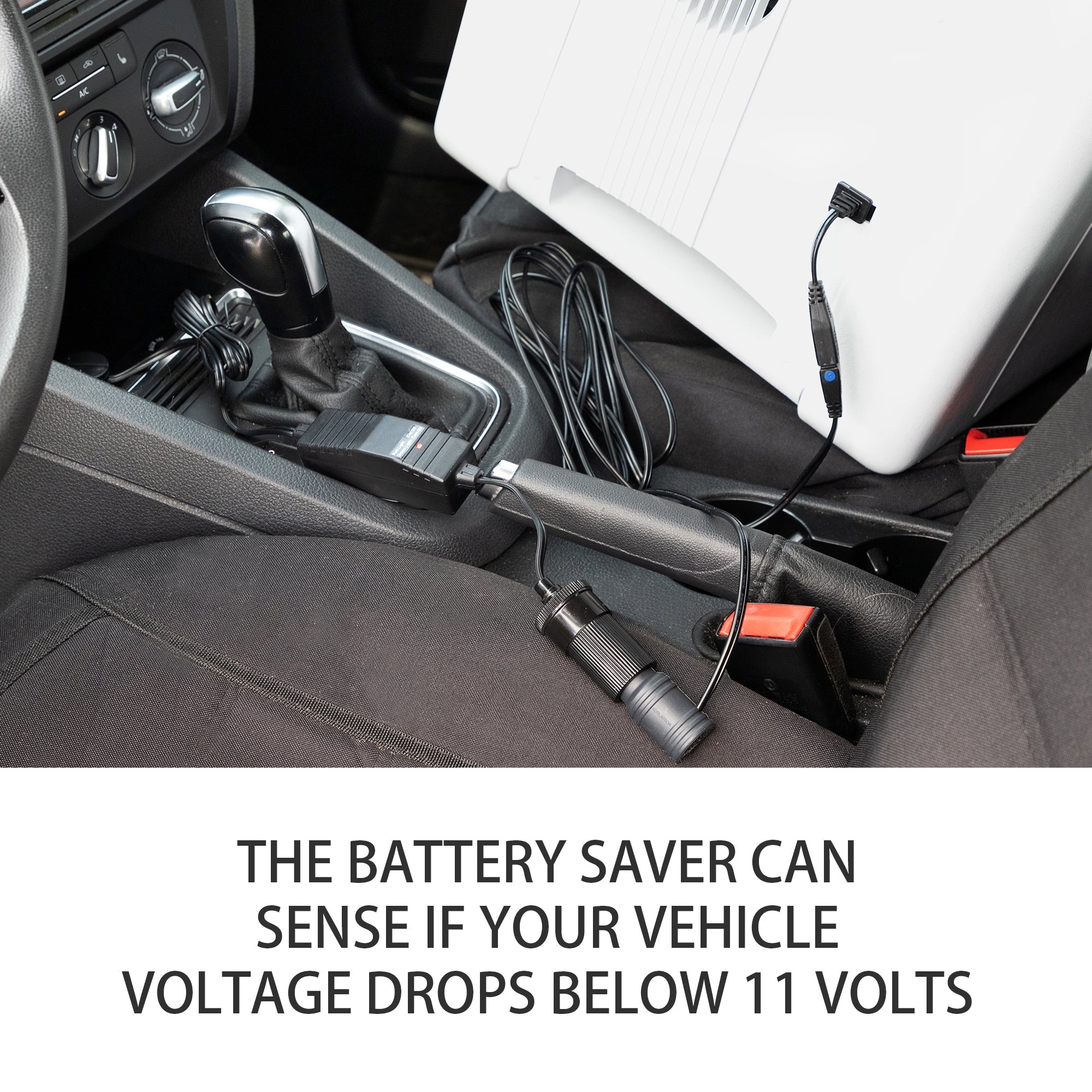 Koolatron 12V Car Battery Saver connected to a 12 volt cooler on the front passenger seat of a car with black upholstery with text below reading, "The battery saver can sense if your vehicle voltage drops below 11 volts"