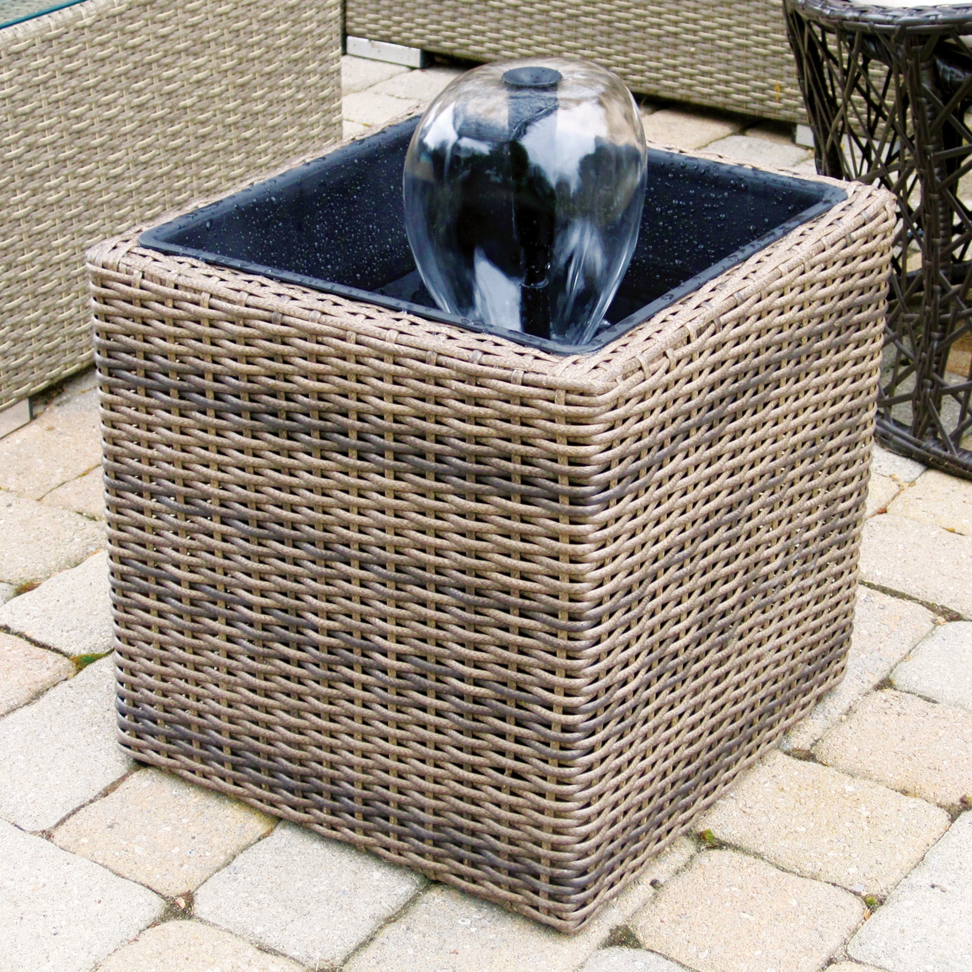 Lifestyle image of Koolscapes wicker-look pond kit with water bell on a brick patio