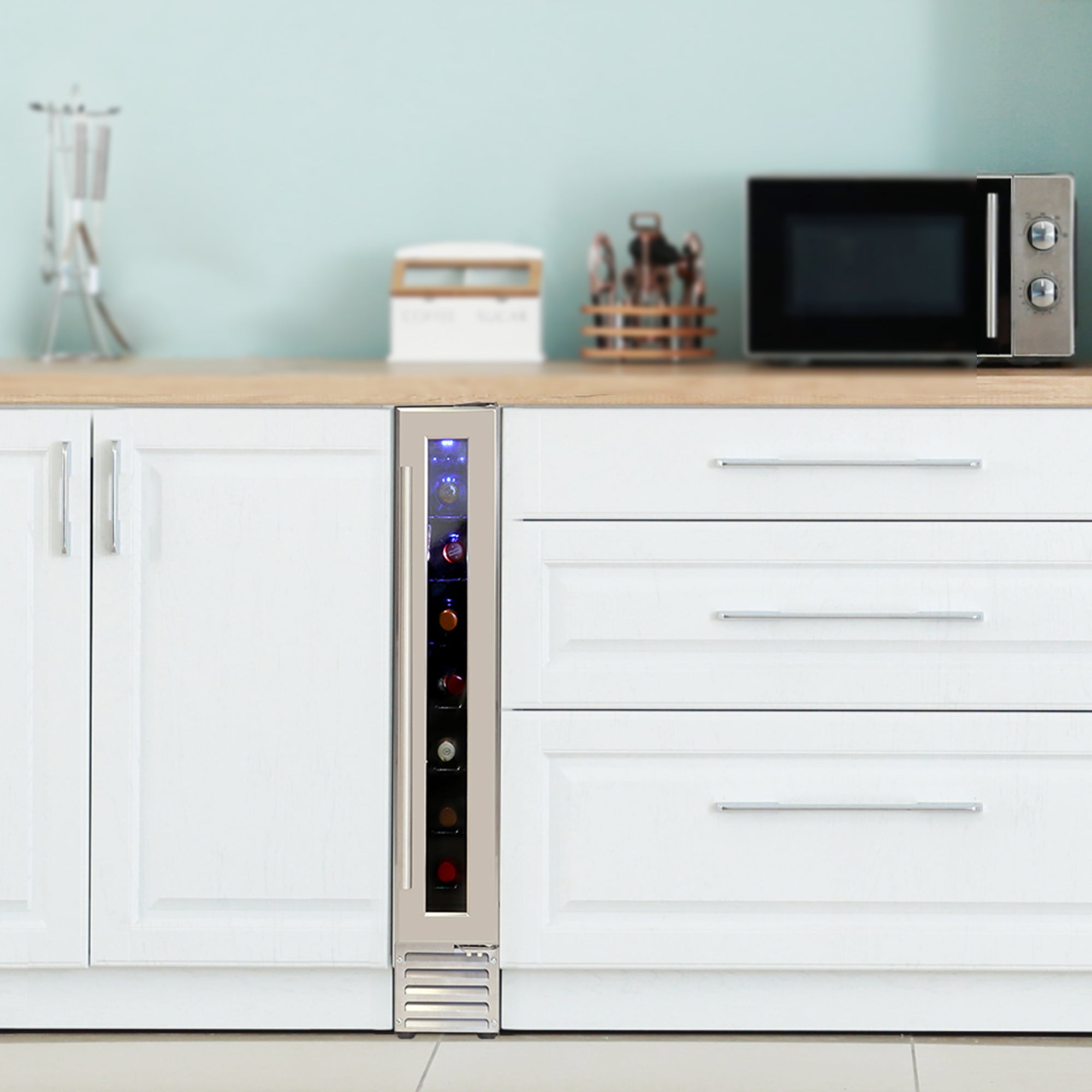 Koolatron slim 7 bottle built-in wine chiller installed between white kitchen cabinets with pale aqua walls and wooden counter