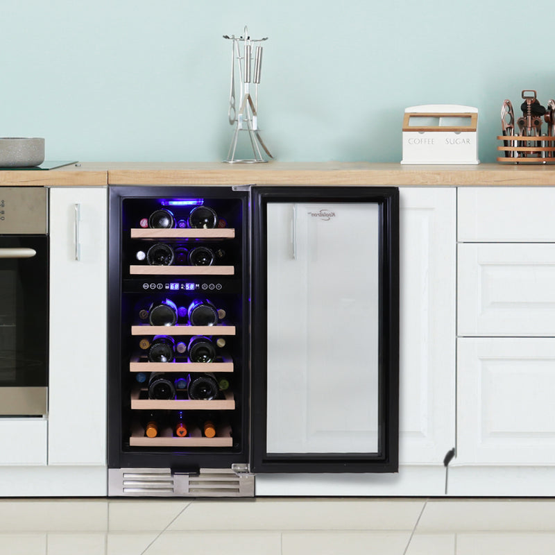 Koolatron dual zone 28 bottle compressor wine fridge, open and filled with bottles of wine, installed between white kitchen cabinets with pale aqua walls and wooden counter