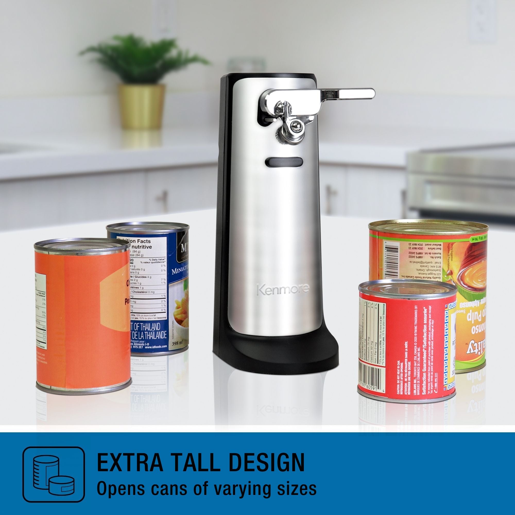 Kenmore 3-in-1 can opener with auto shut-off on a white marble counter with various sized cans positioned on either side of it. Text below reads, "EXTRA TALL DESIGN: Opens cans of varying sizes"