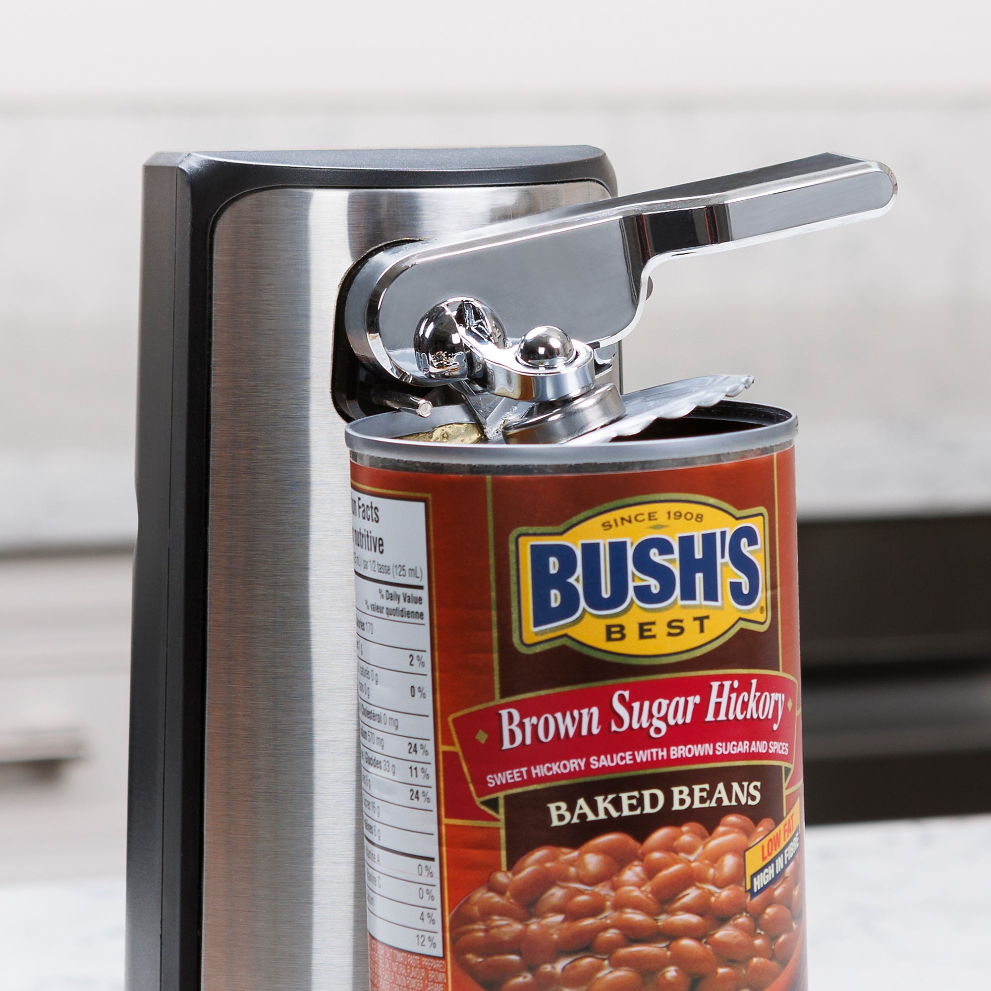 Closeup view of the Kenmore 3-in-1 stainless steel can opener opening a can of baked beans