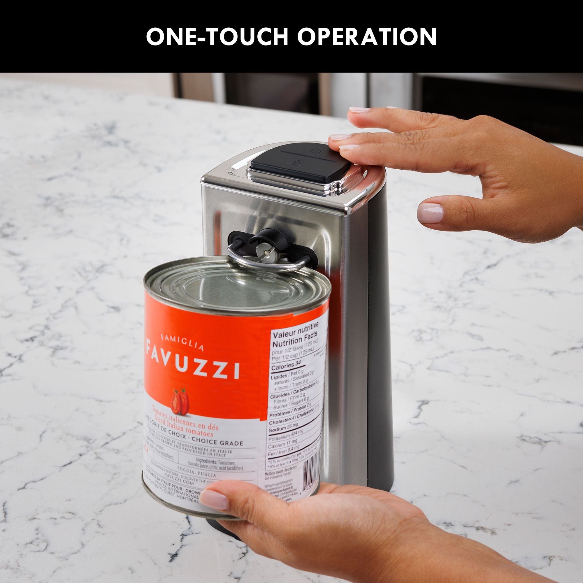 A person's hands holding a can and pressing the button on top of the Kenmore smooth-edge can opener on a white marble kitchen counter. Text above reads, "One-touch operation"