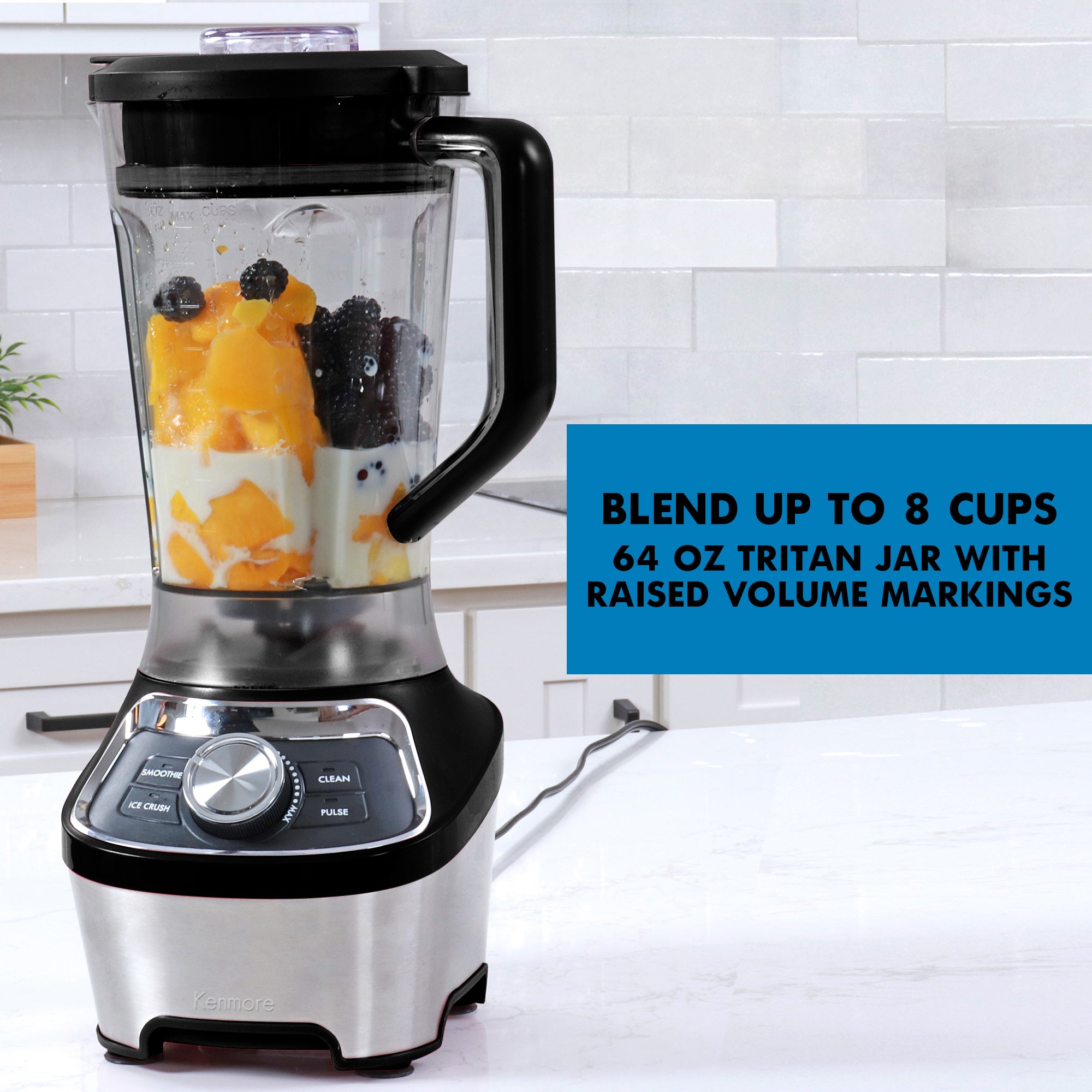 Blender filled with peaches, milk, blackberries and blueberries on a white marble kitchen counter with a white tile backsplash behind it. Text overlay reads, Blend up to 8 cups: 64 oz Tritan jar with raised volume markings.