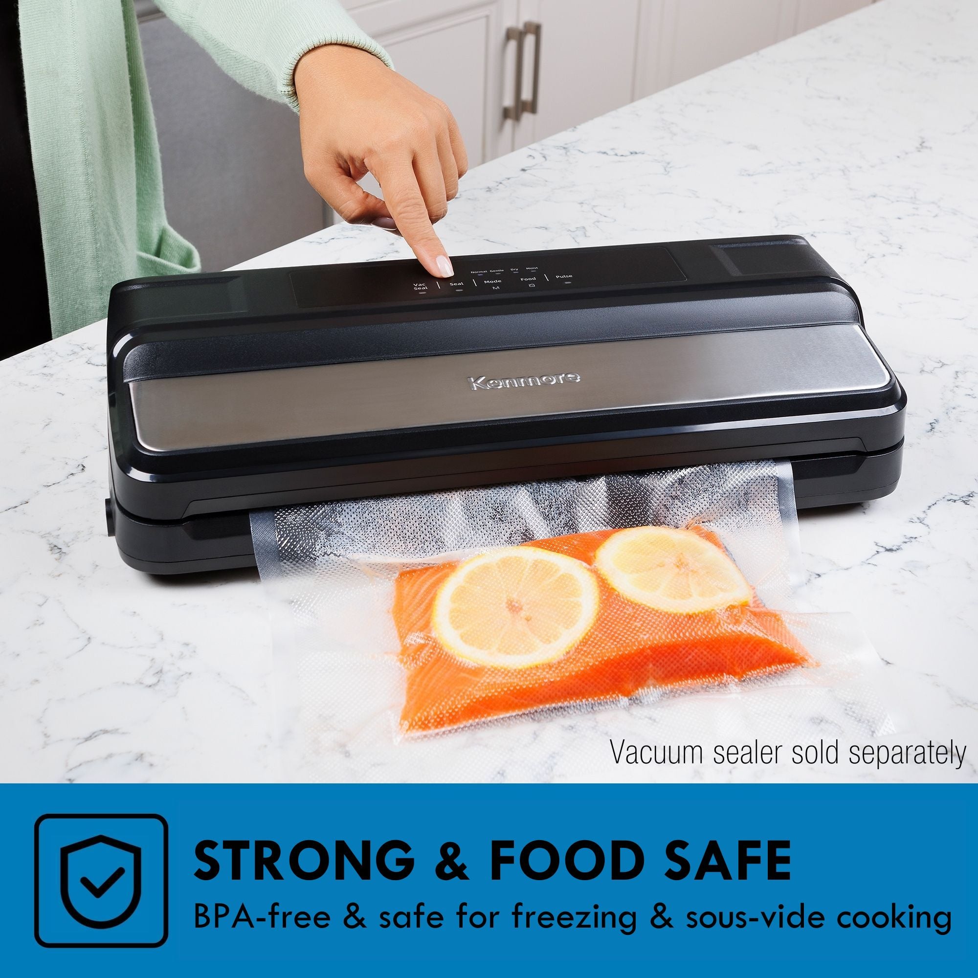 Kenmore vacuum sealer on a white and gray marble surface with a bag containing salmon and lemon slices and a person in a pale green cardigan touching the controls. Text below reads, "Strong and food-safe: BPA-free and safe for freezing and sous-vide cooking"