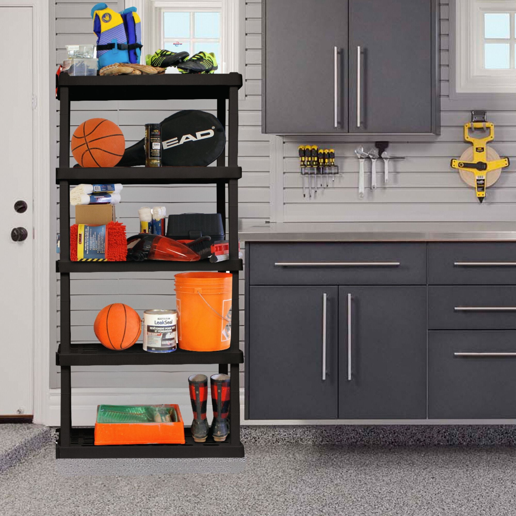 Oskar 5-tier shelving unit loaded with sports and outdoor equipment in a garage beside a gray workbench