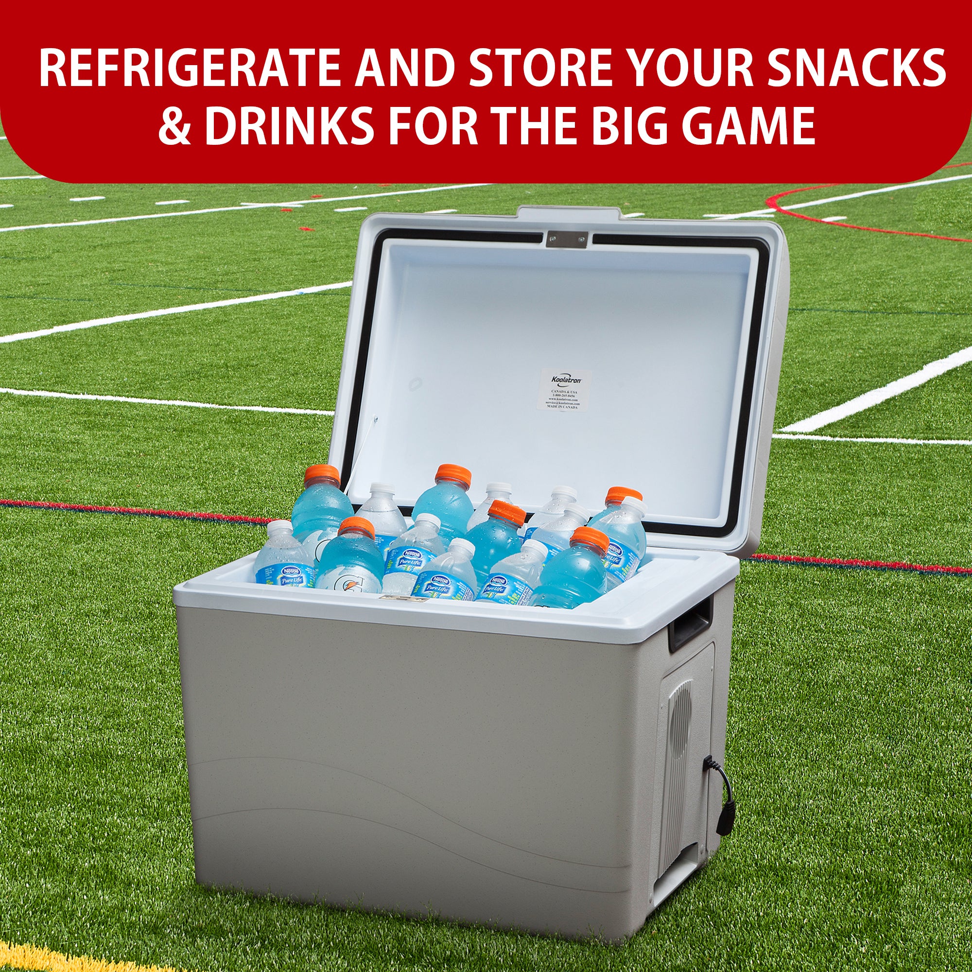 Koolatron portable 12V cooler/warmer open and filled with water bottles and sports drinks on a grass sports field. Text above reads, "REFRIGERATE AND STORE YOUR SNACKS AND DRINKS FOR THE BIG GAME"