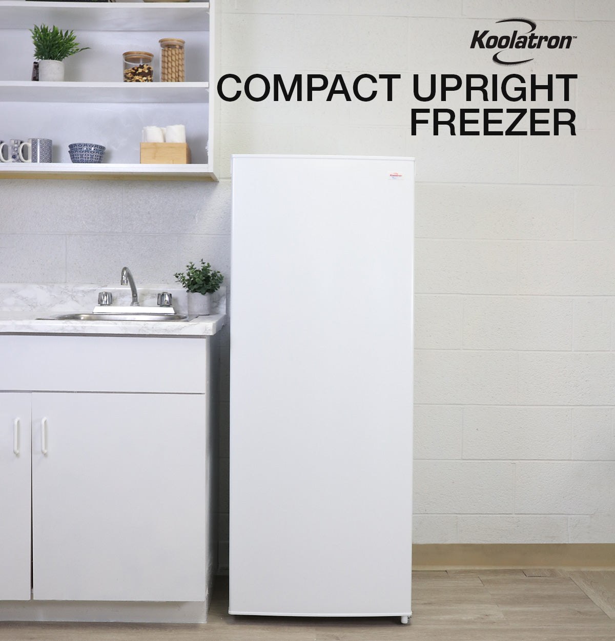 Lifestyle image of upright freezer beside a white kitchen cabinet with white marble countertop. Text above reads "Koolatron compact upright freezer"