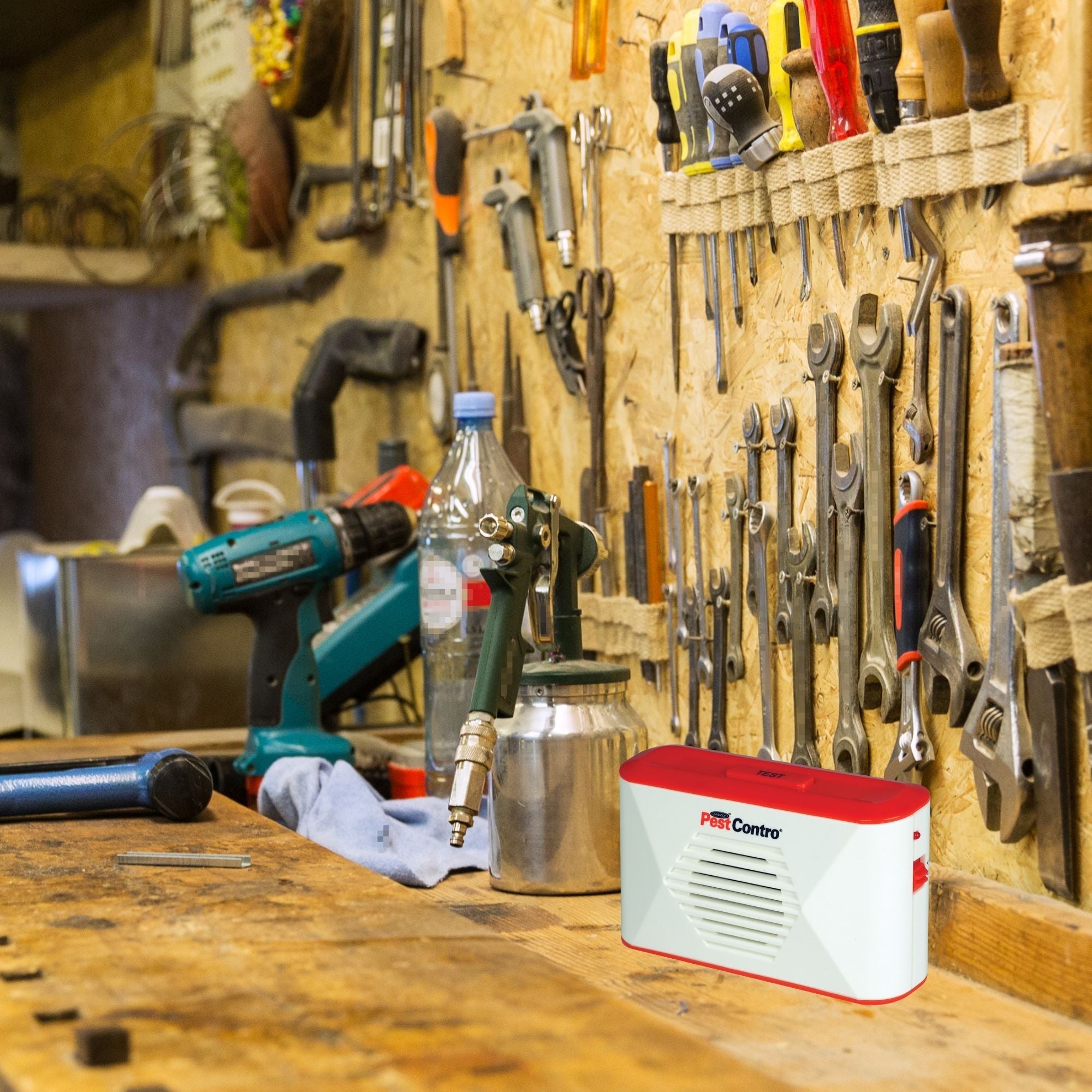 Lifestyle image of PestContro portable ultrasonic rodent repeller on a wooden work bench surrounded by tools