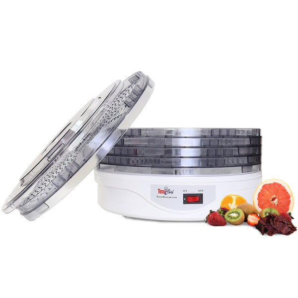 Product shot of food dehydrator on white background with lid leaning against it an assortment of fruit beside it