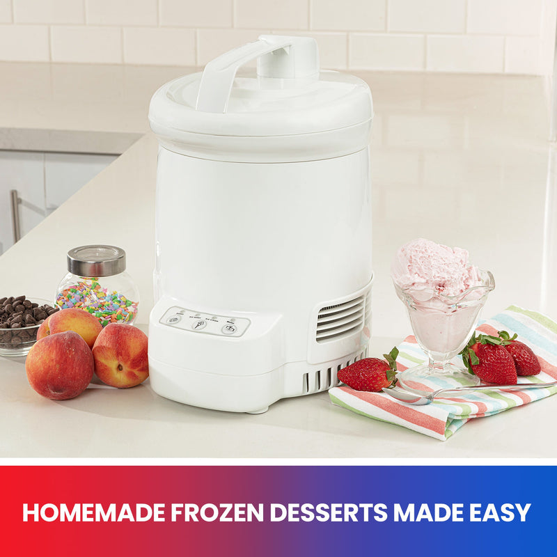 Lifestyle image of ice cream maker on a white counter with a cup of light pink ice cream, strawberries, a spoon, and a striped napkin to the right and peaches, a jar of sprinkles, and a bowl of chocolate chips to the left. Text below reads, "Homemade frozen desserts made easy"