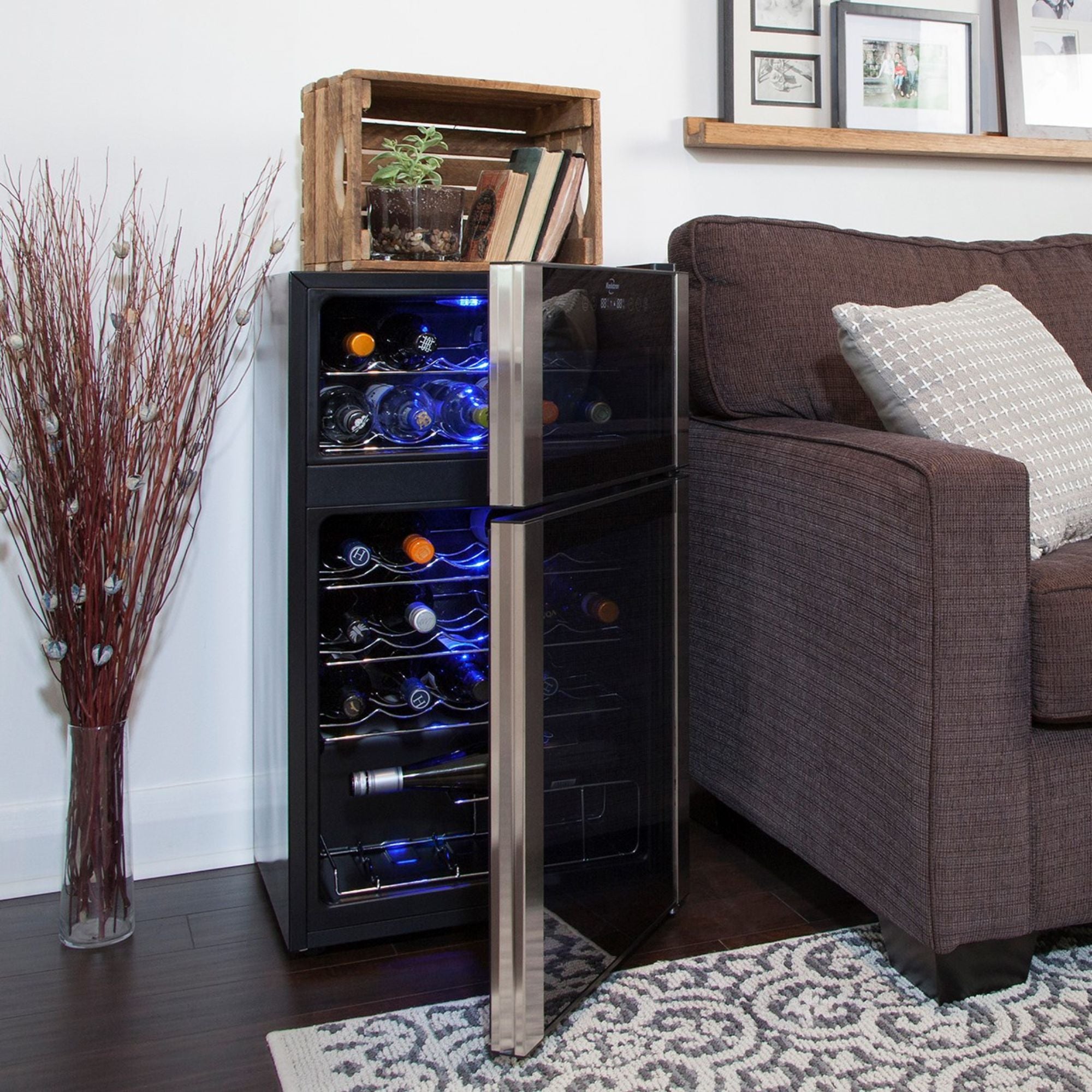 Koolatron 29 bottle dual zone freestanding wine fridge, open and filled with bottles of wine, set up in an elegant living room beside a brown sofa