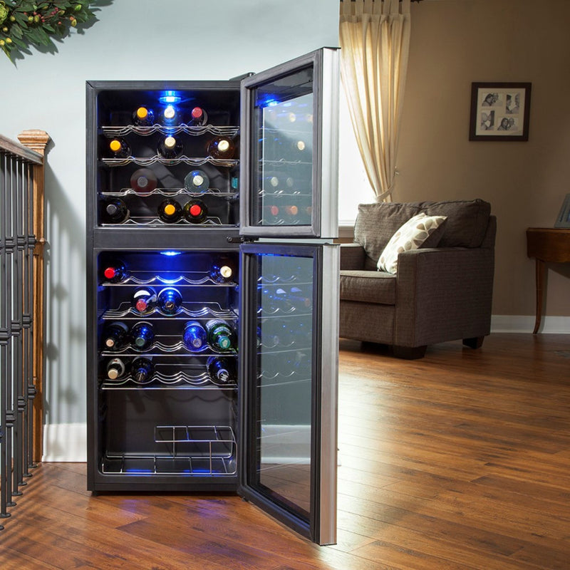 Lifestyle image of wine fridge, open and filled with bottles of wine, on reddish-brown hardwood floor with a brown sofa in the background