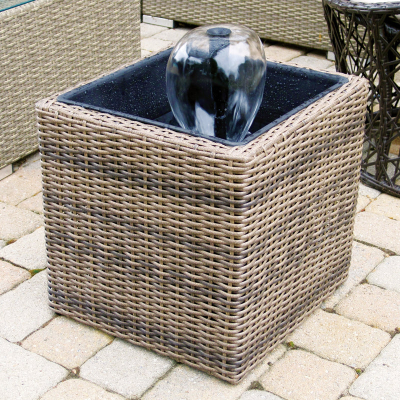 Lifestyle image of Koolscapes wicker-look pond kit with water bell on a brick patio 